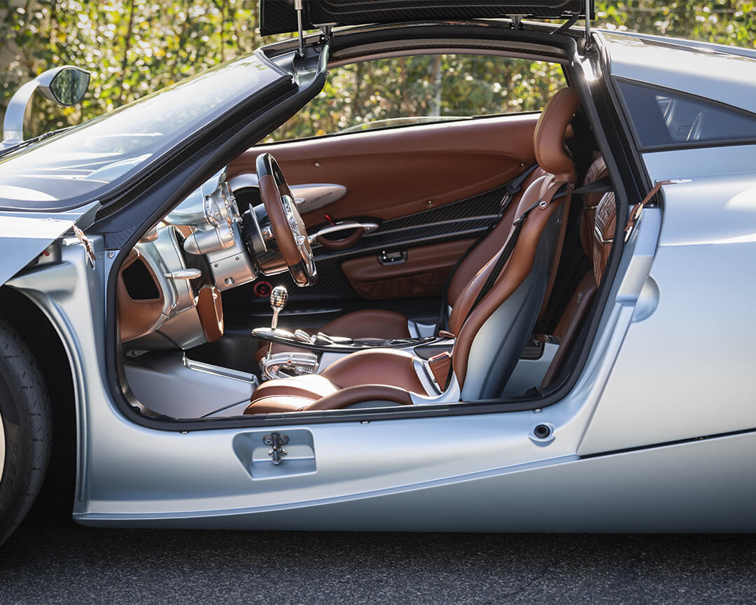 vista dell'abitacolo di una pagani huayra con interni marroni e vernice azzurra