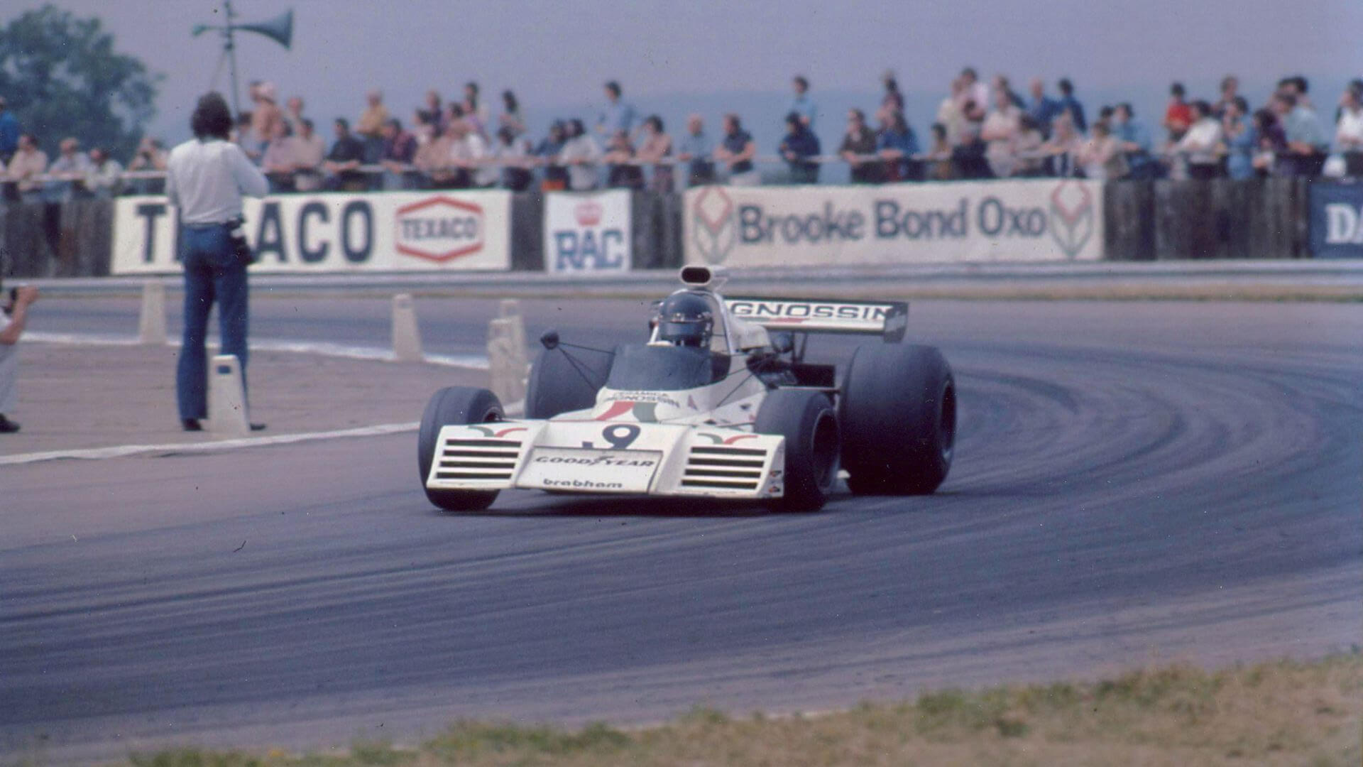 Una vecchia foto a colori ritrae una monoposto d'epoca che affronta una curva di un tracciato