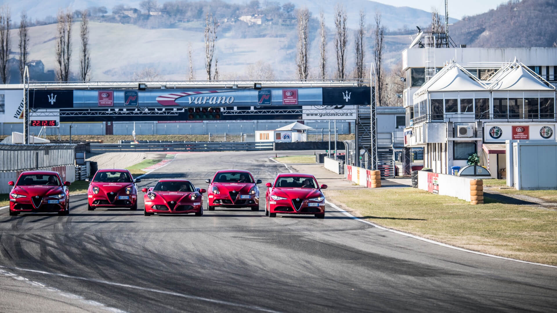 Due giulia quadrifoglio, una alfaromeo 4C, una mito ed una giulietta, guidano in formazione mentre percorrono il rettilineo del circuito di varano