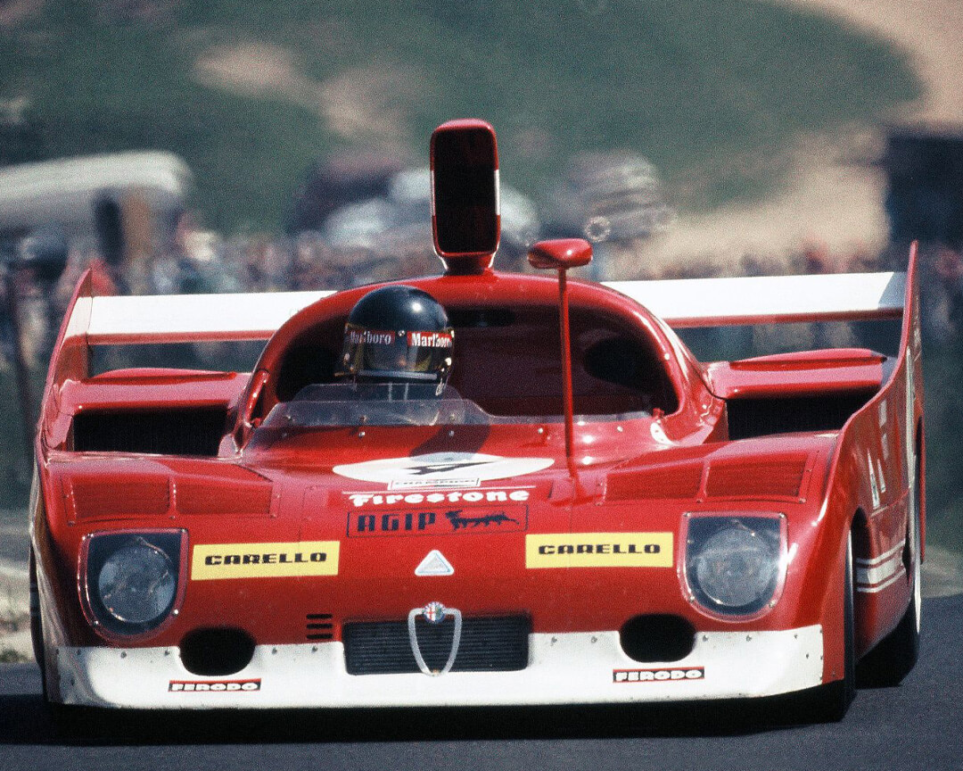 Una vecchia foto a colori ritrae una vettura da scalata alfa romeo che affronta un tracciato