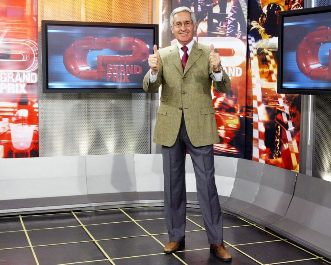 Andrea de adamich che con i pollici alzati all'interno dello studio Grand prix