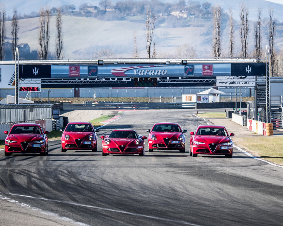 Due giulia quadrifoglio, una alfaromeo 4C, una mito ed una giulietta, guidano in formazione mentre percorrono il rettilineo del circuito di varano