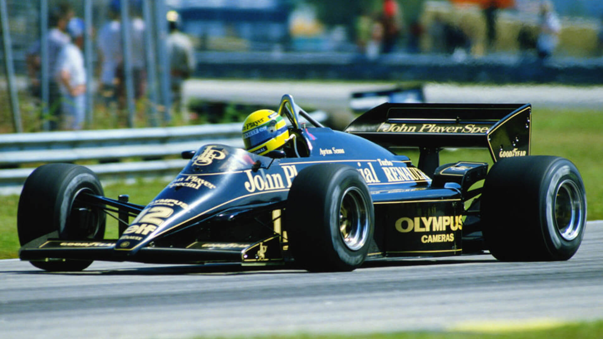 Legendary Formula 1 single-seater, the black and gold Lotus 97T sponsored by John Player Special, with driver Ayrton Senna behind the wheel during a race.