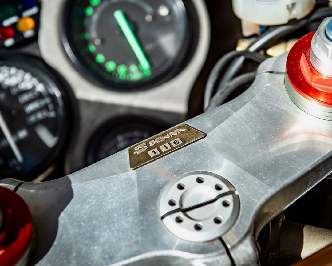 Dettaglio della forcella della ducati 916 senna, sulla forcella si vede una placca con scritto senna e il numero del modello e sullo sfondo il cruscotto