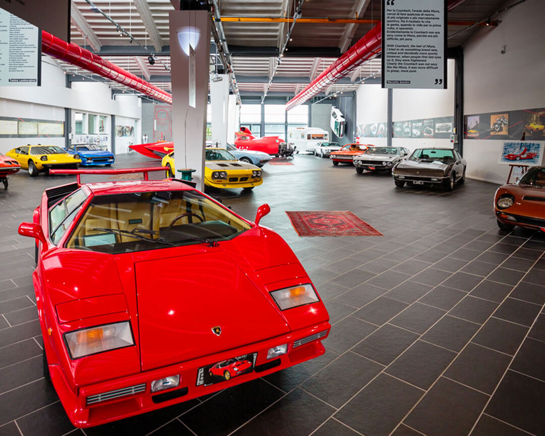 All'interno del museo ferruccio lamborghini in primo piano si vede una lamborghini countach rossa insieme ad altri modelli storici lamborghini