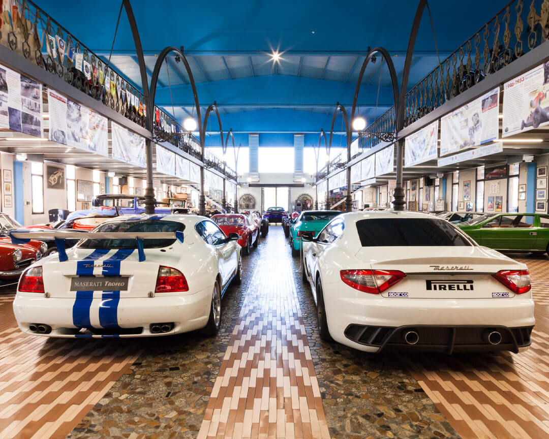 Foto della sala principale della collezione panini dove si possono vedere in primo piano due maserati storiche e molte altre esposte