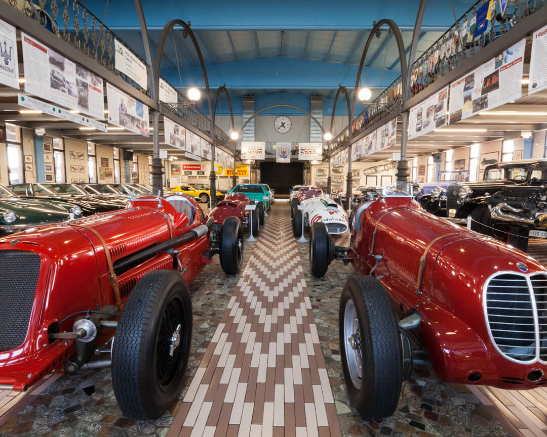 All'interno della collezione panini in primo piano si possono vedere due modelli maserati d'epoca insieme alla maserati eldorado in secondo piano e a molte altre vetture storiche del marchio