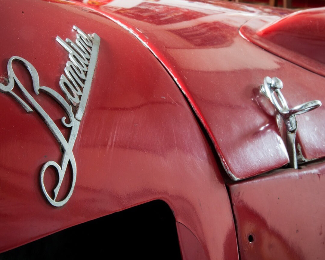 dettaglio su logo Bandini punzonato sulla carrozzeria rossa di una macchina
