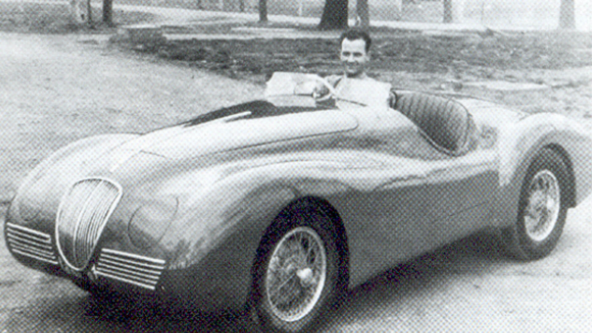un giovane Ilario Bandini seduto su un'auto di sua crezione, foto in bianco e nero