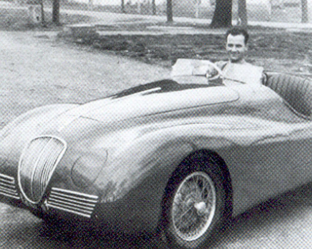 un giovane Ilario Bandini seduto su un'auto di sua crezione, foto in bianco e nero