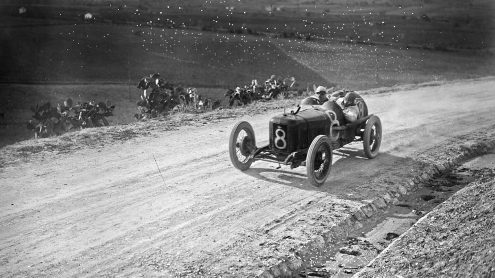Foto d'epoca in bianco e nero di una vecchia maserati da corsa con il numero 8