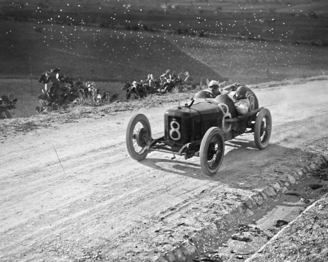Foto d'epoca in bianco e nero di una vecchia maserati da corsa con il numero 8