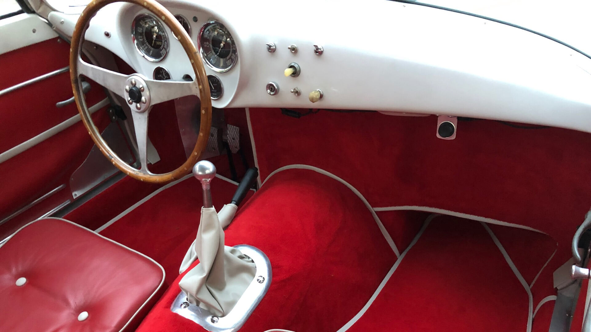 dettaglio di interno rosso con volante marrone di auto d'epoca Bandini