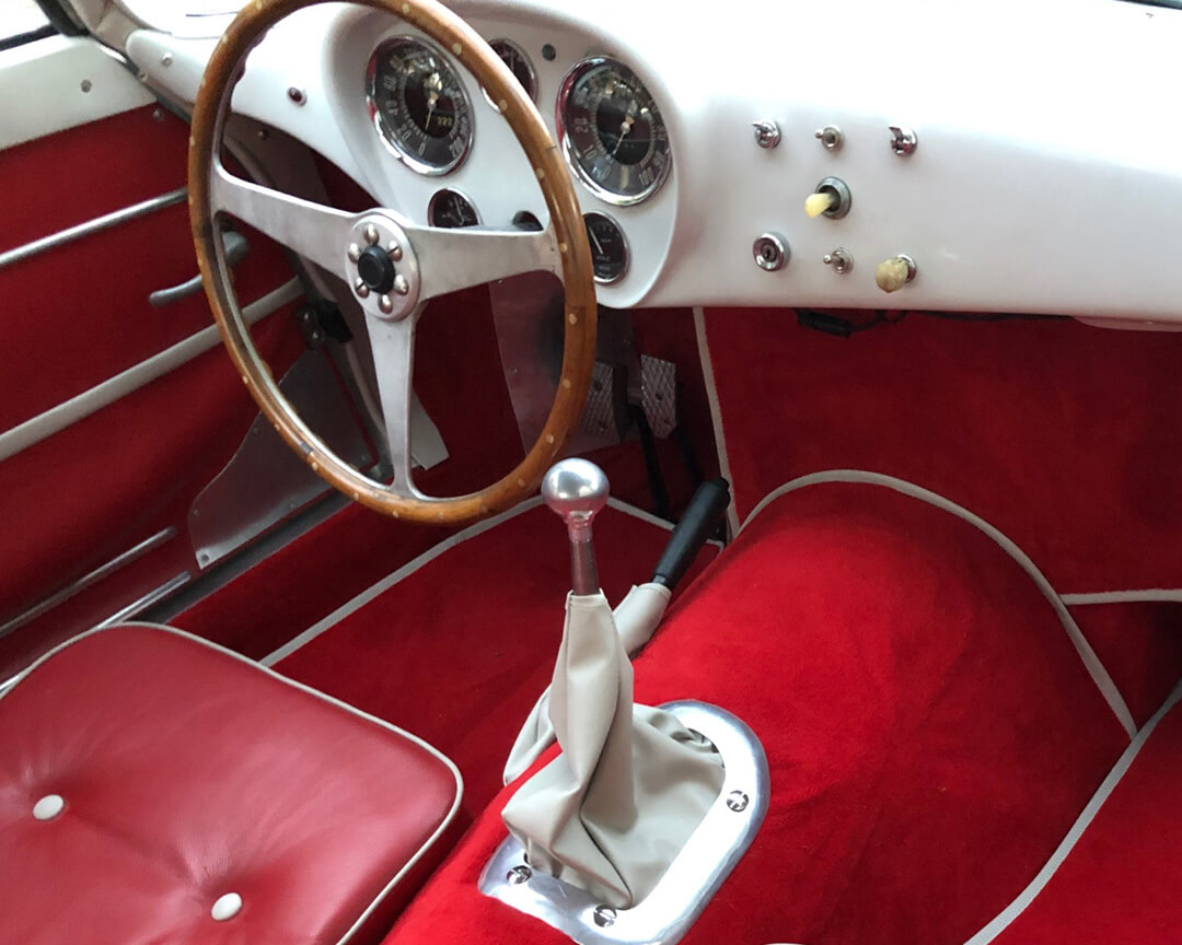 dettaglio di interno rosso con volante marrone di auto d'epoca Bandini