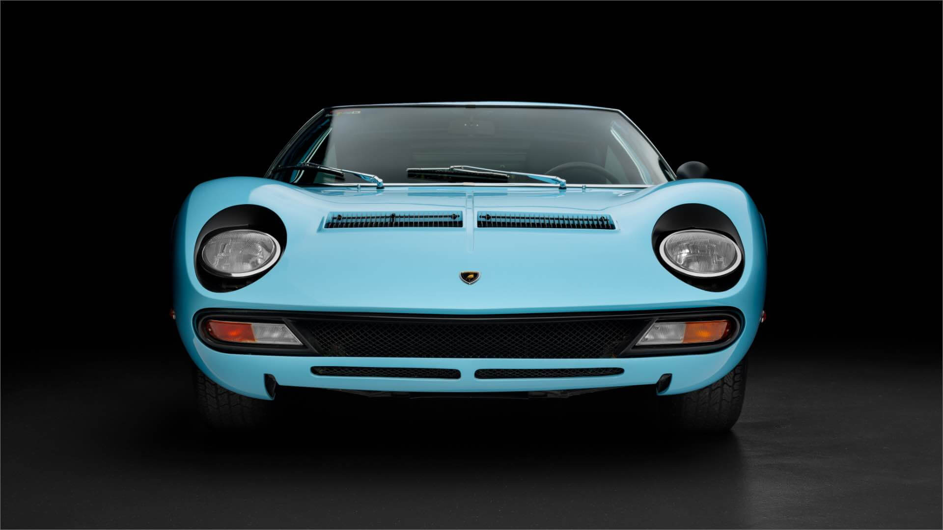 Lamborghini Miura SV azzurra vista da davanti con sfondo nero