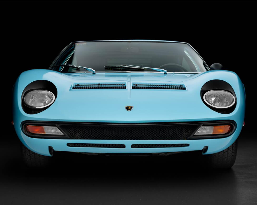 Lamborghini Miura SV azzurra vista da davanti con sfondo nero