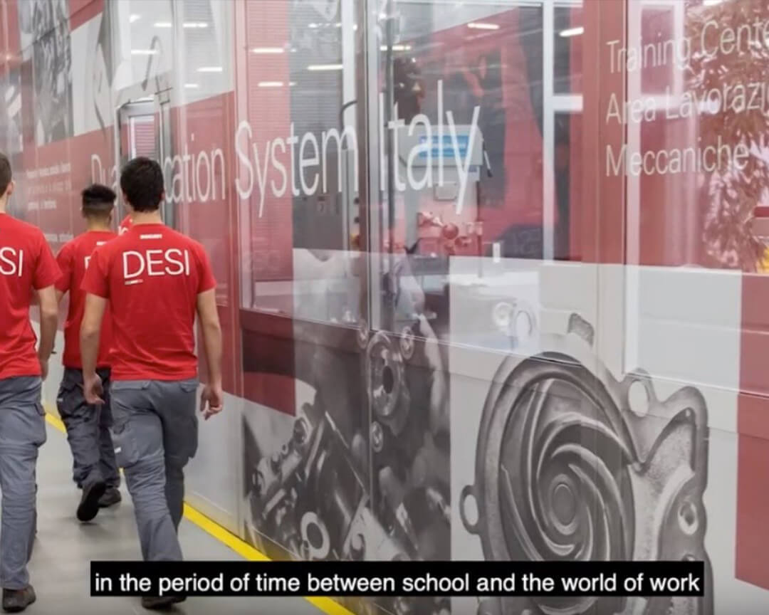 A group of mechanics walk down a DESI hallway.