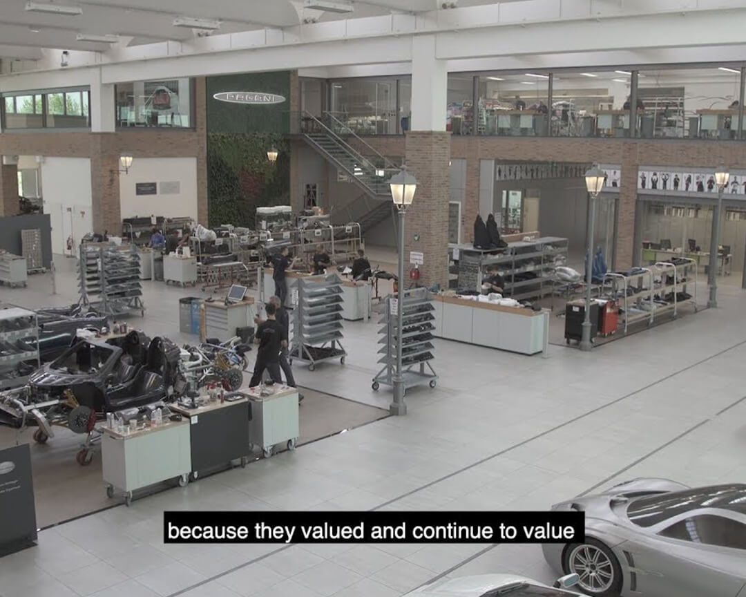Foto della sede pagani vista dall'interno, con vetture pagani in costruzioni e i sottotitoli dell'intervista ad horacio pagani