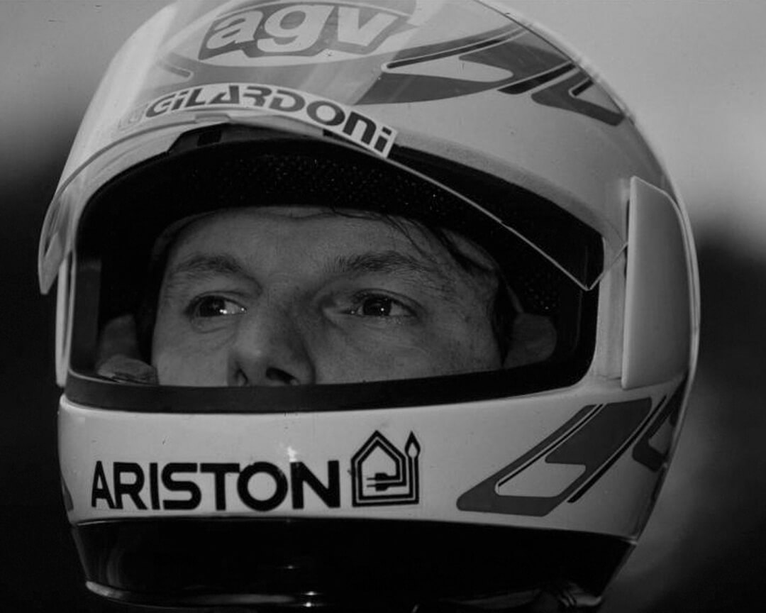 black and white photo of Fausto Gresini with motogp racing helmet
