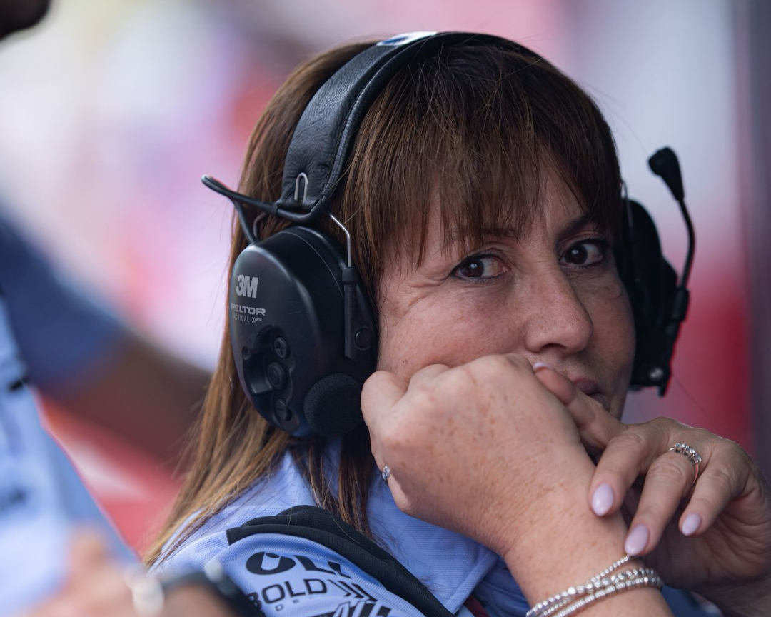 photo of Nadia Padovani with headphones and microphone with head resting on hand