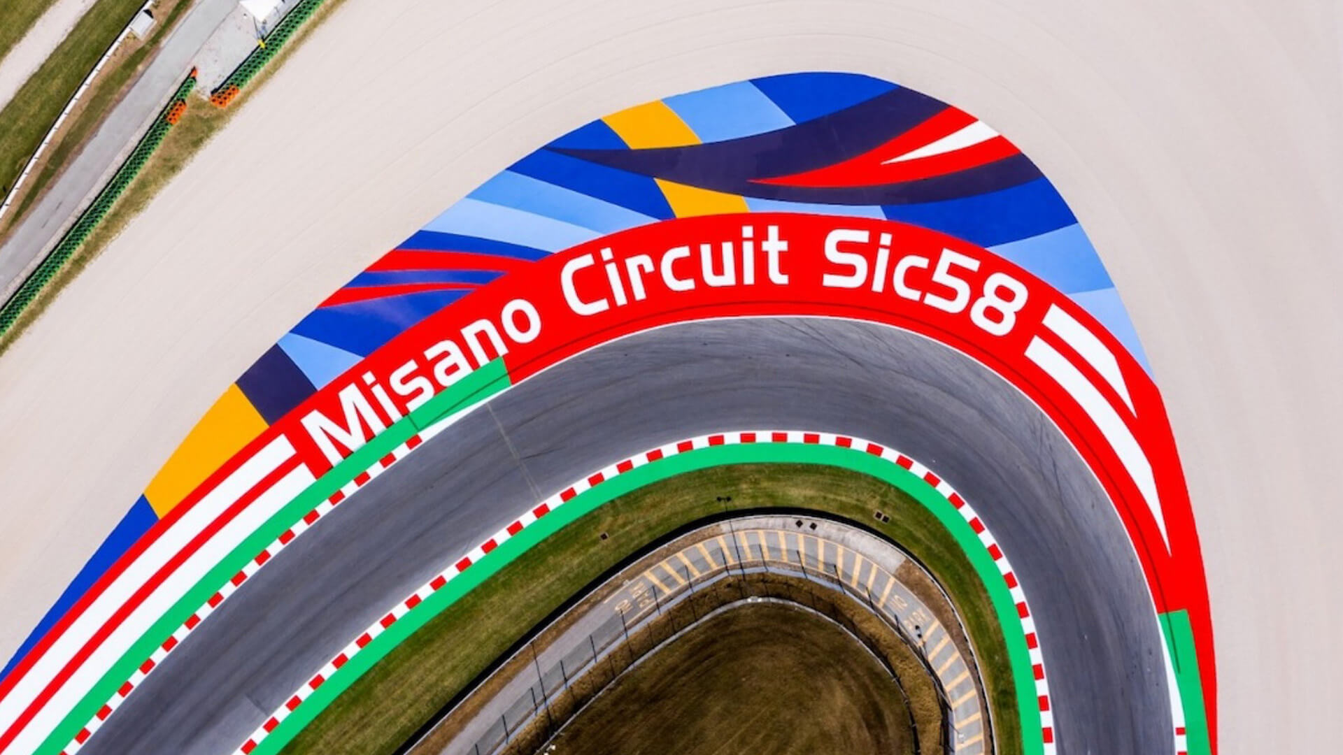 A curve of the misano circuit, where in addition to the curb there is the writing printed on the ground “misano curcuit Sic58”