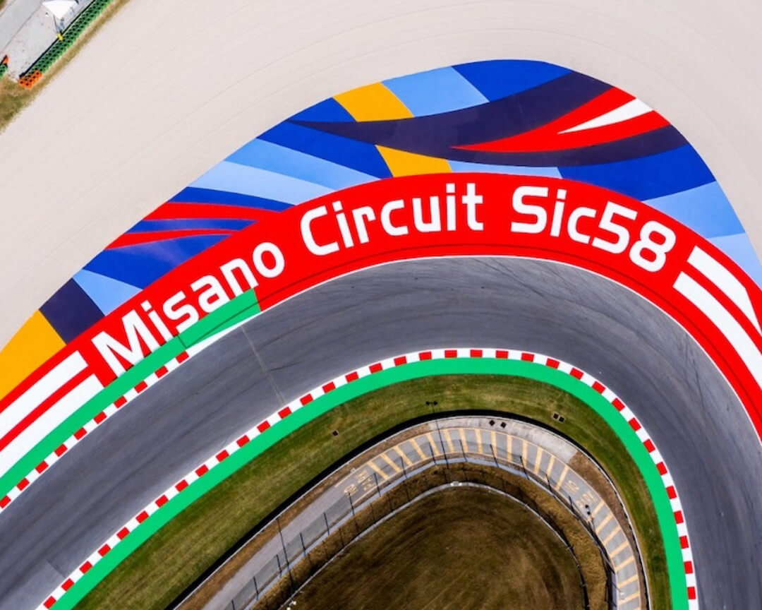 A curve of the misano circuit, where in addition to the curb there is the writing printed on the ground “misano curcuit Sic58”