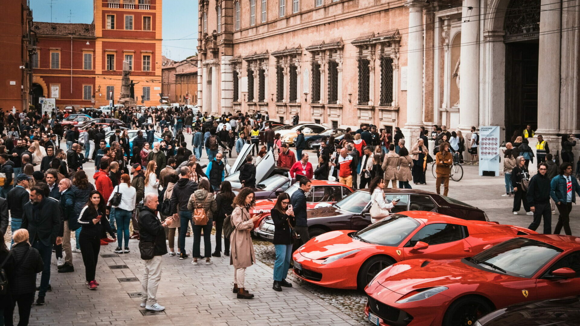 piazza con Ferrari esposte e persone durante evento