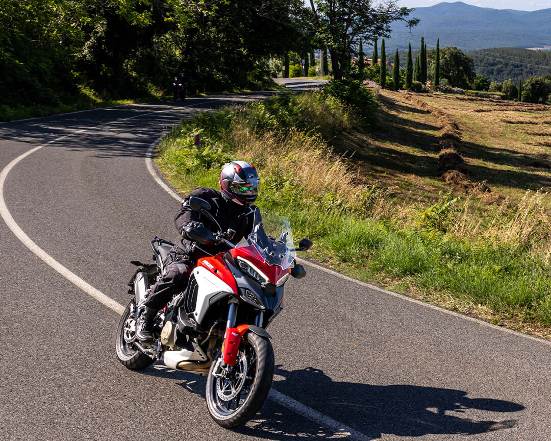 Rider riding Ducati Multistrada in Tuscan countryside