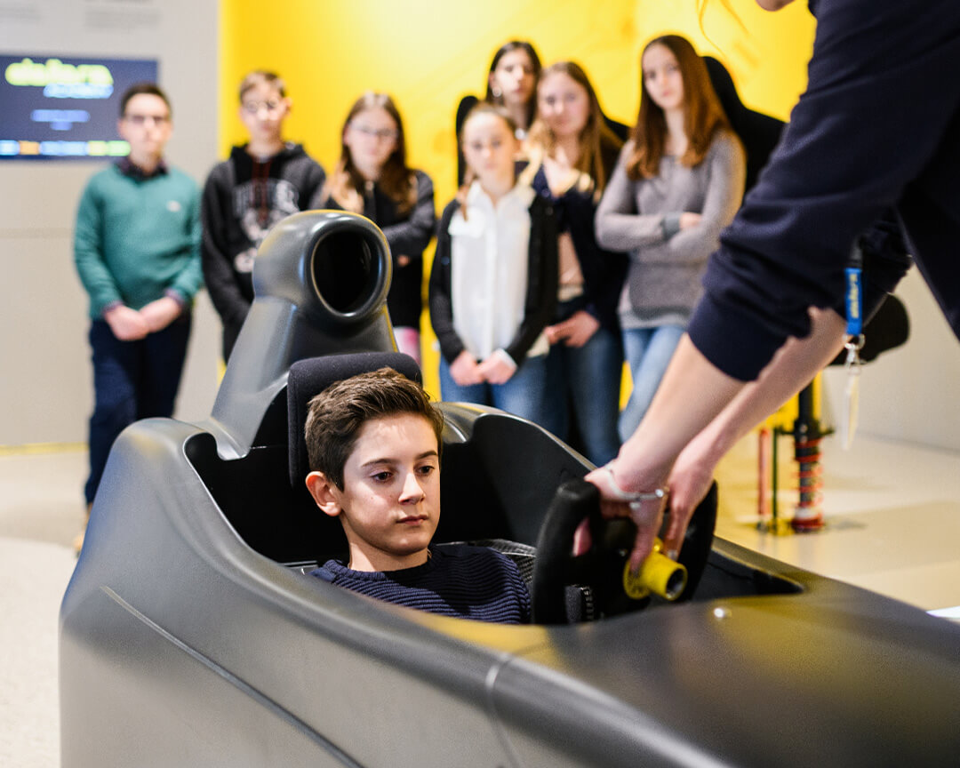 Middle school boy experiences driving a sports car at Dallara educational workshop