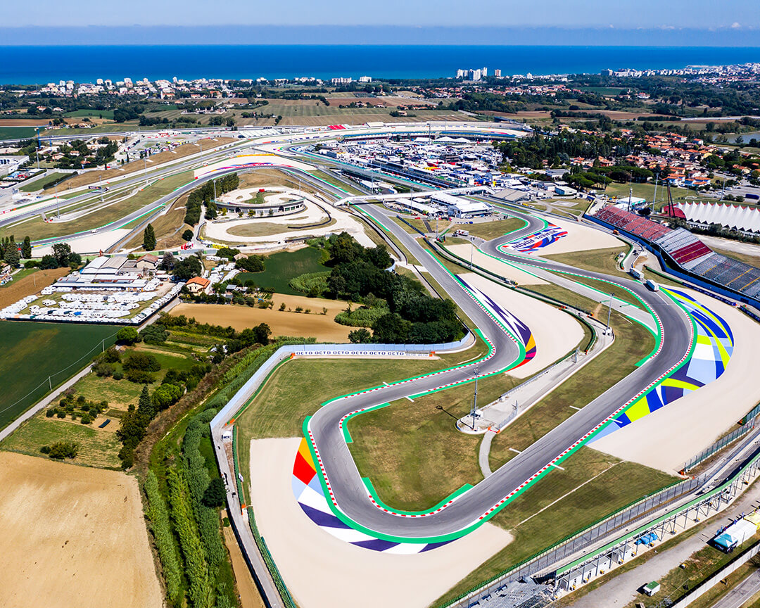 vista aerea del circuito di Misano con le sue curve colorate, le strutture e il mare sullo sfondo all'orizzonte