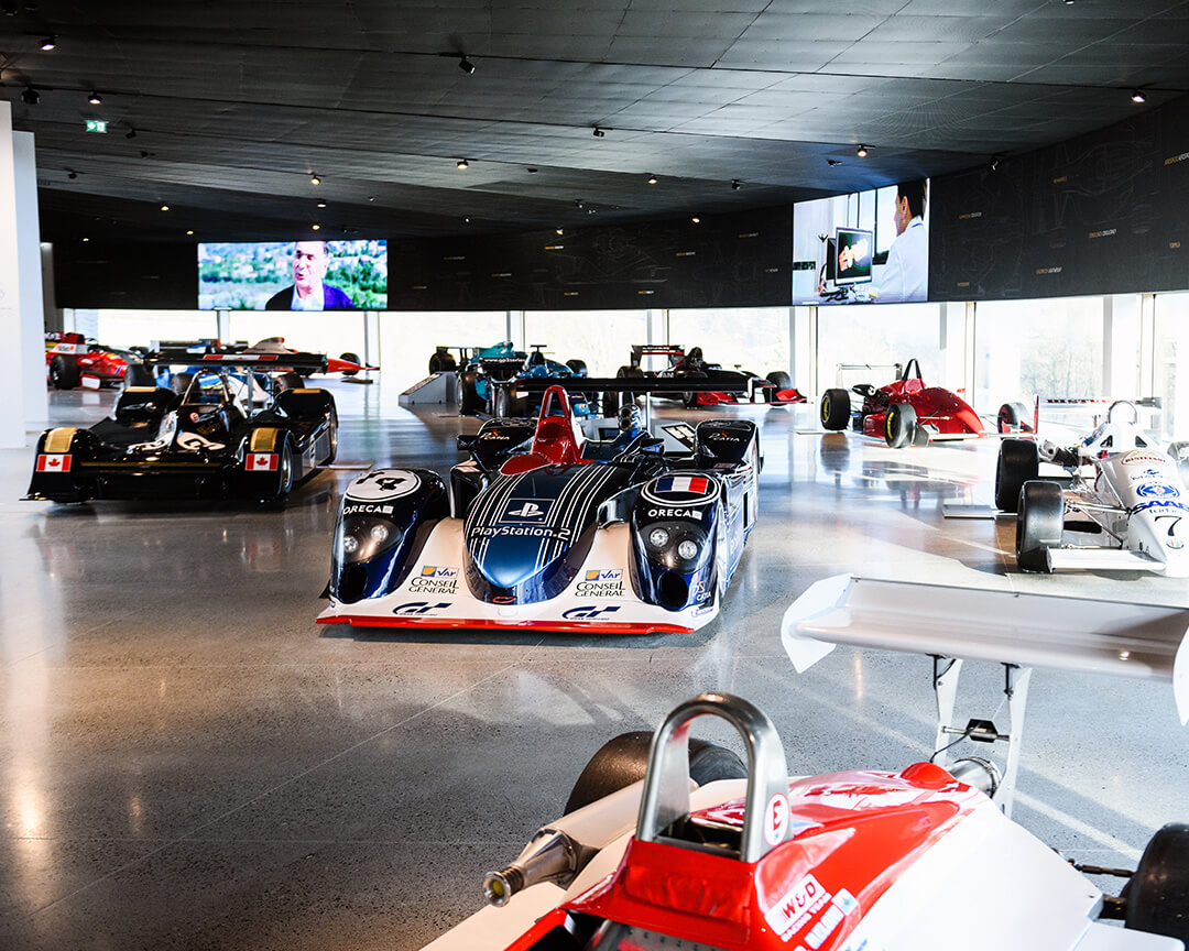 several formula indy and 24-hour le mans cars on display at the Dallara Academy exhibition ramp