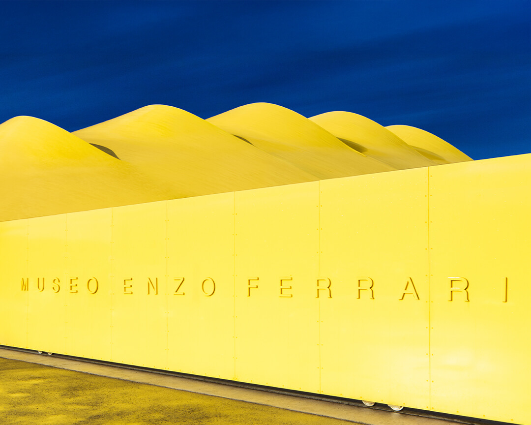 Architectural detail of the Enzo Ferrari Museum's yellow pavilion with embossed name