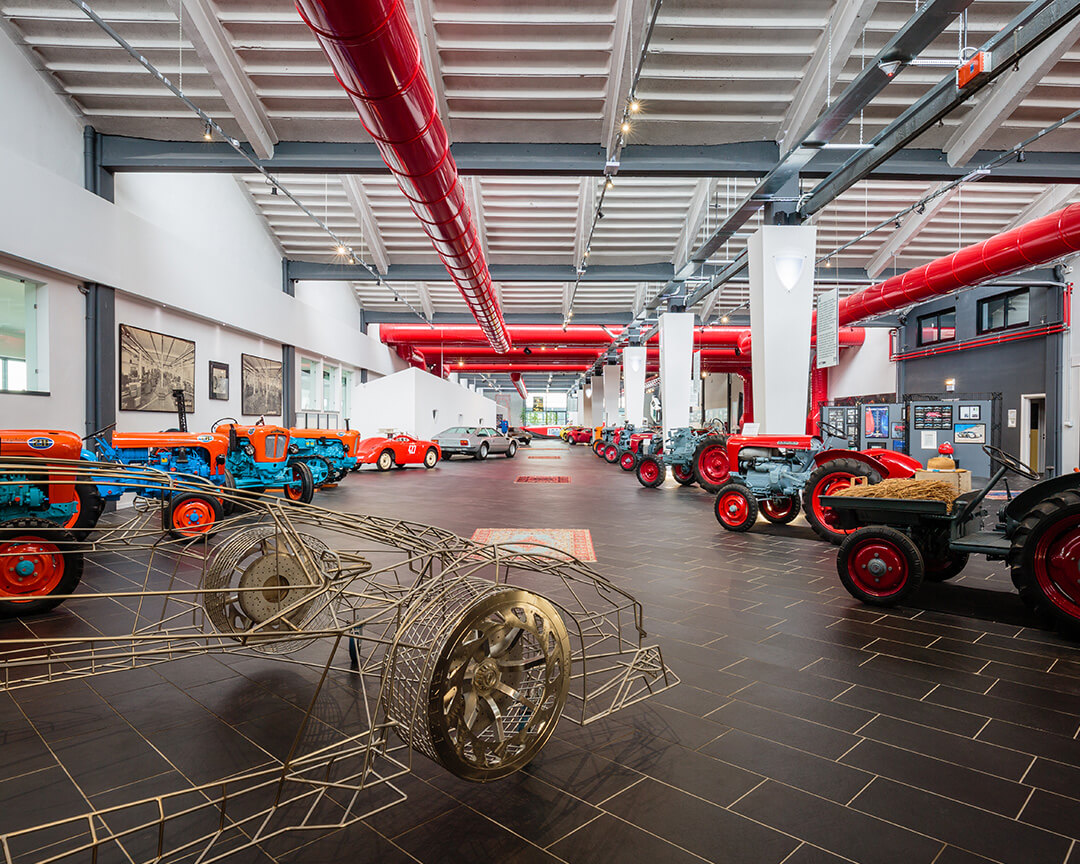 overview room of ferruccio lamborghini museum with all tractor models and a wireframe of a car body