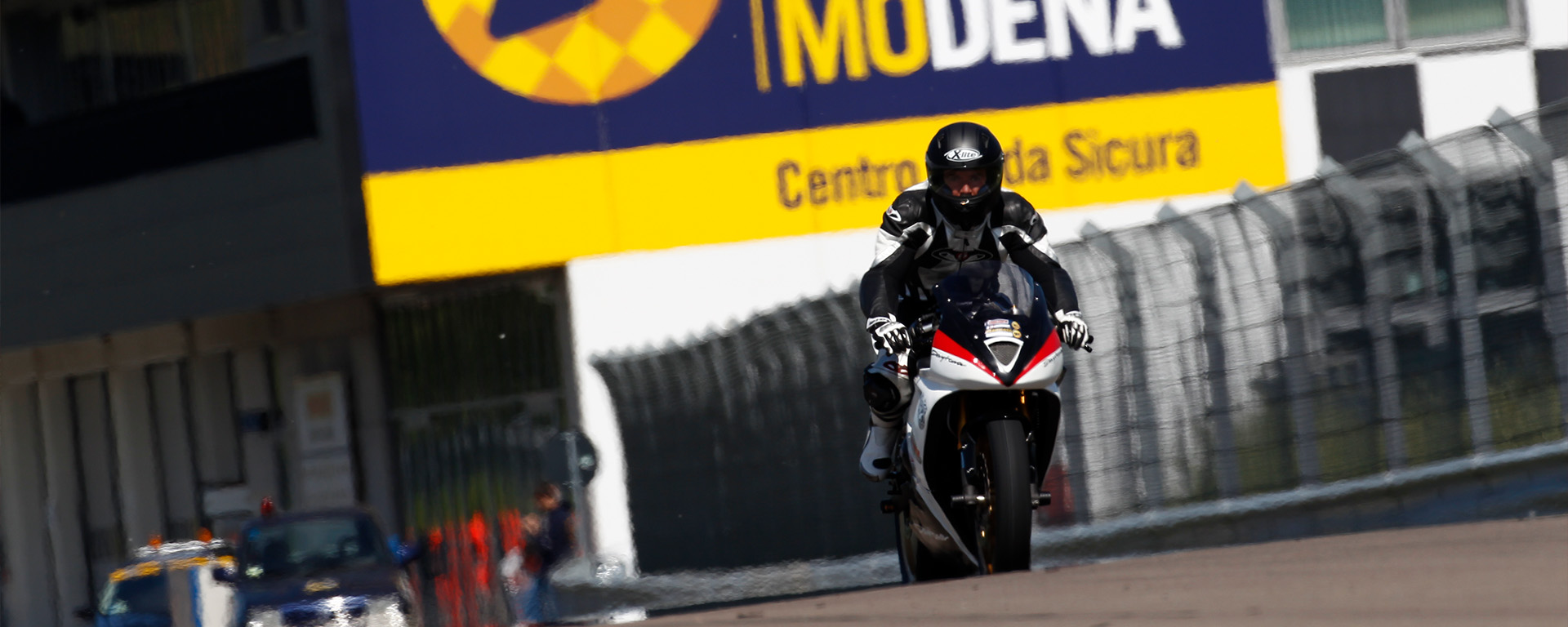 Moto in pista nell'autodromo di Modena con banner dietro.