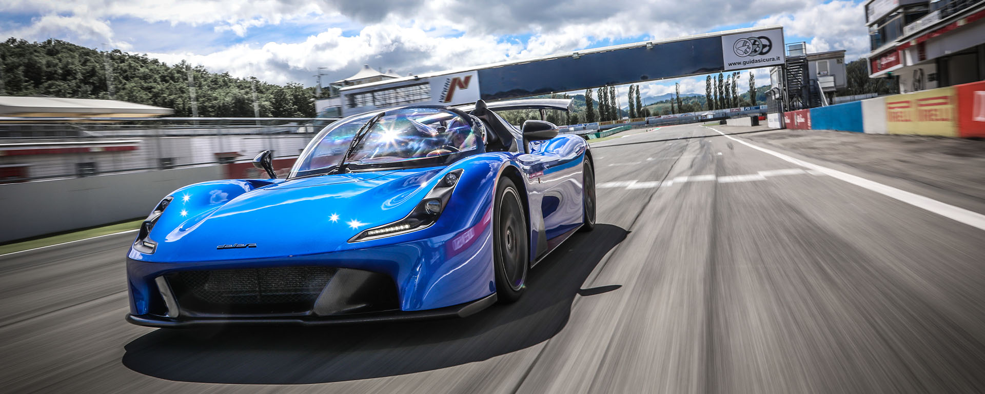 Dallara Stradale blu in pista al circuito di Varano con cielo nuvoloso e ad alta velocità