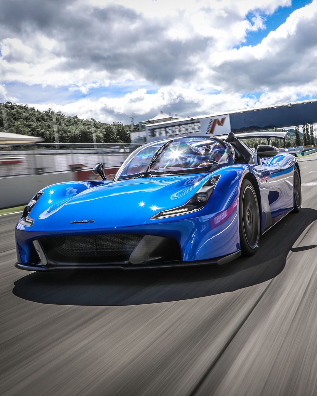 Dallara Stradale blu in pista al circuito di Varano con cielo nuvoloso e ad alta velocità