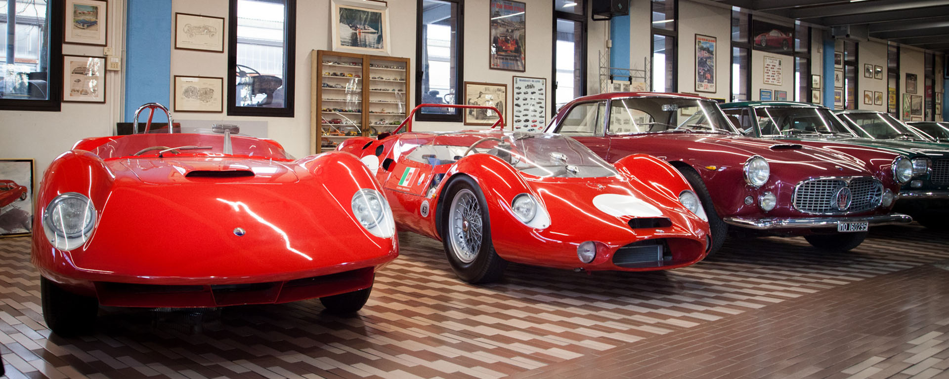Sala principale della Collezione Panini con auto rosse da corsa e stradali d'epoca
