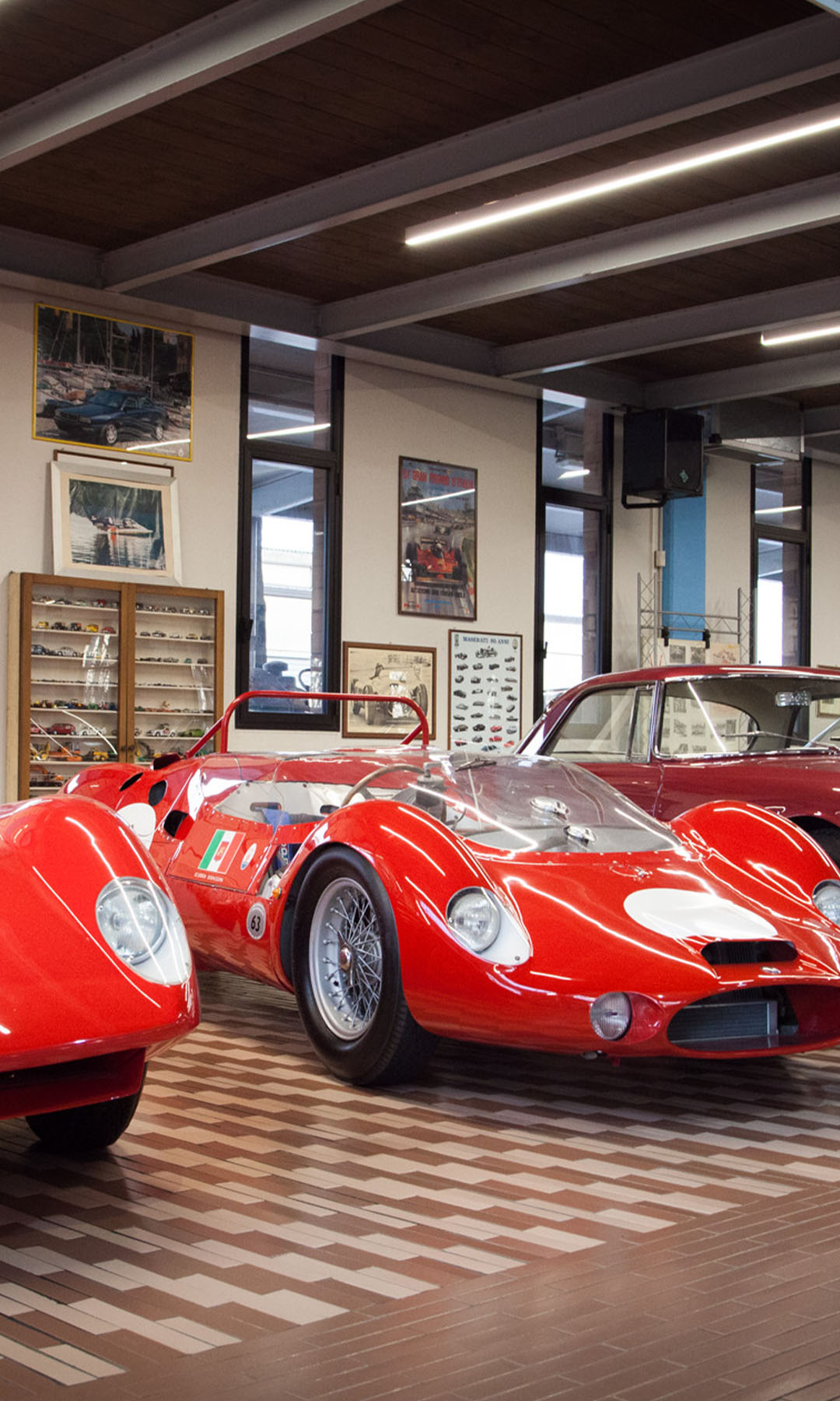 Sala principale della Collezione Panini con auto rosse da corsa e stradali d'epoca