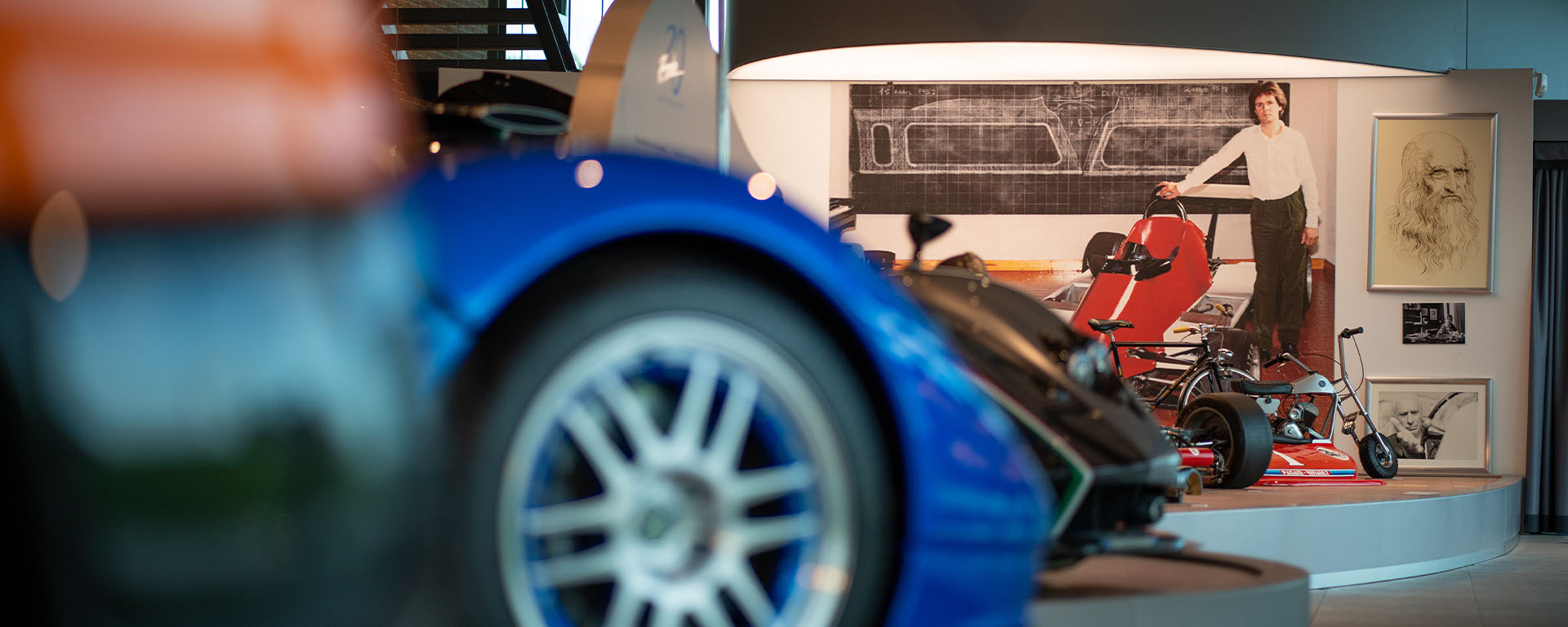 Dettaglio di una sala espositiva del Museo Pagani con foto di Horacio da giovane e modelli di automobili sfocate