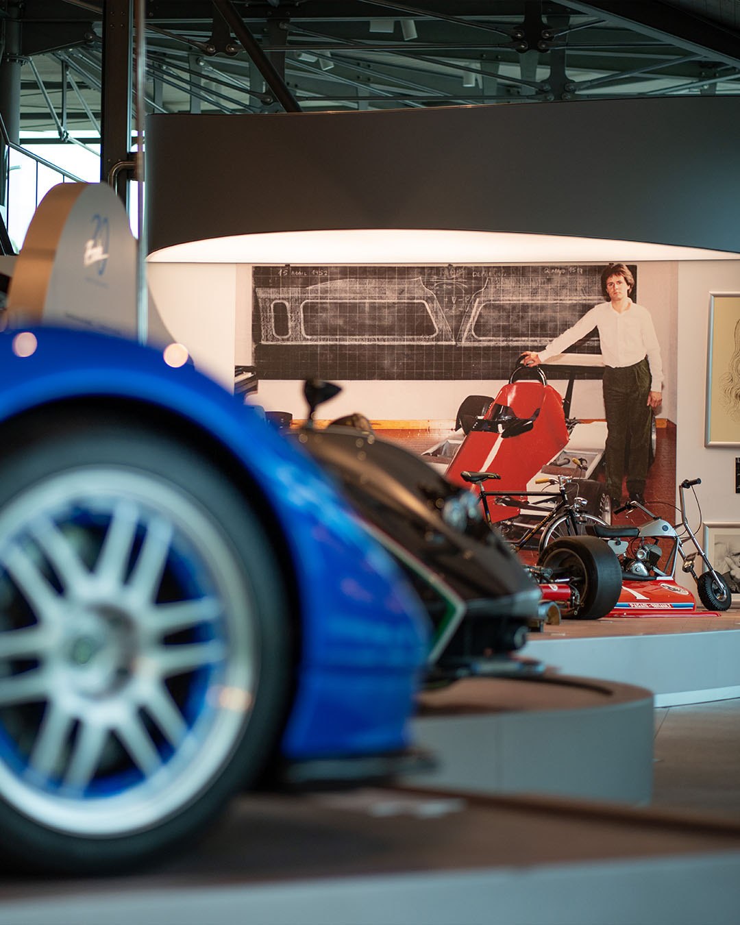 Dettaglio di una sala espositiva del Museo Pagani con foto di Horacio da giovane e modelli di automobili sfocate