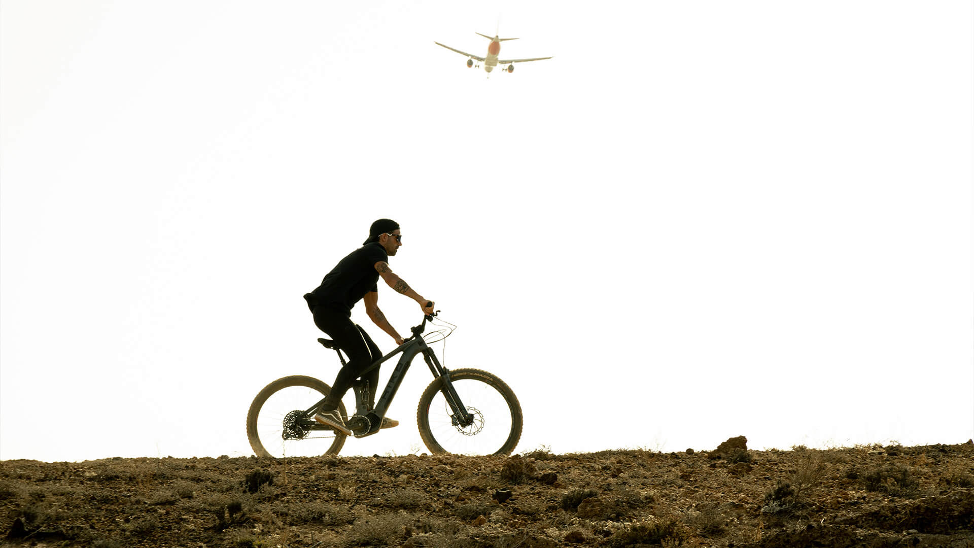 athlete running on a beltrami bike with a plane in the background