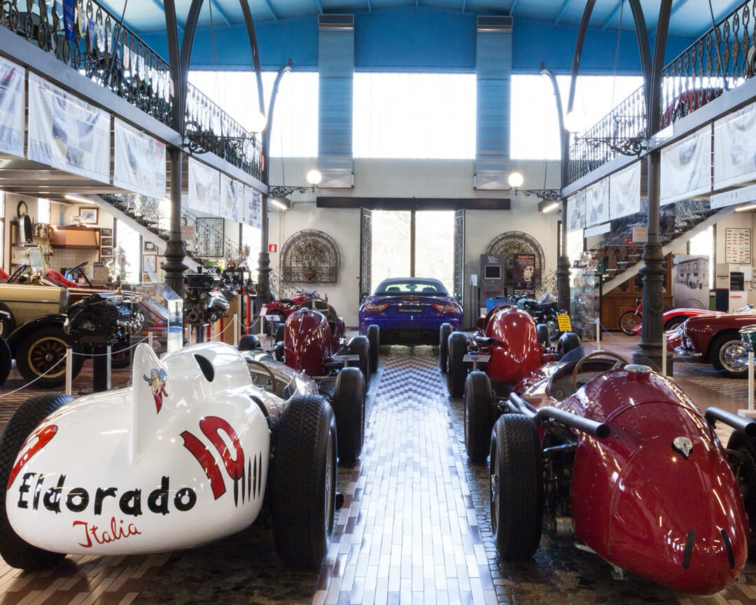 Maserati single-seater cars parked in a showroom and in the foreground Eldorado model with Eldorado Italia lettering on the front