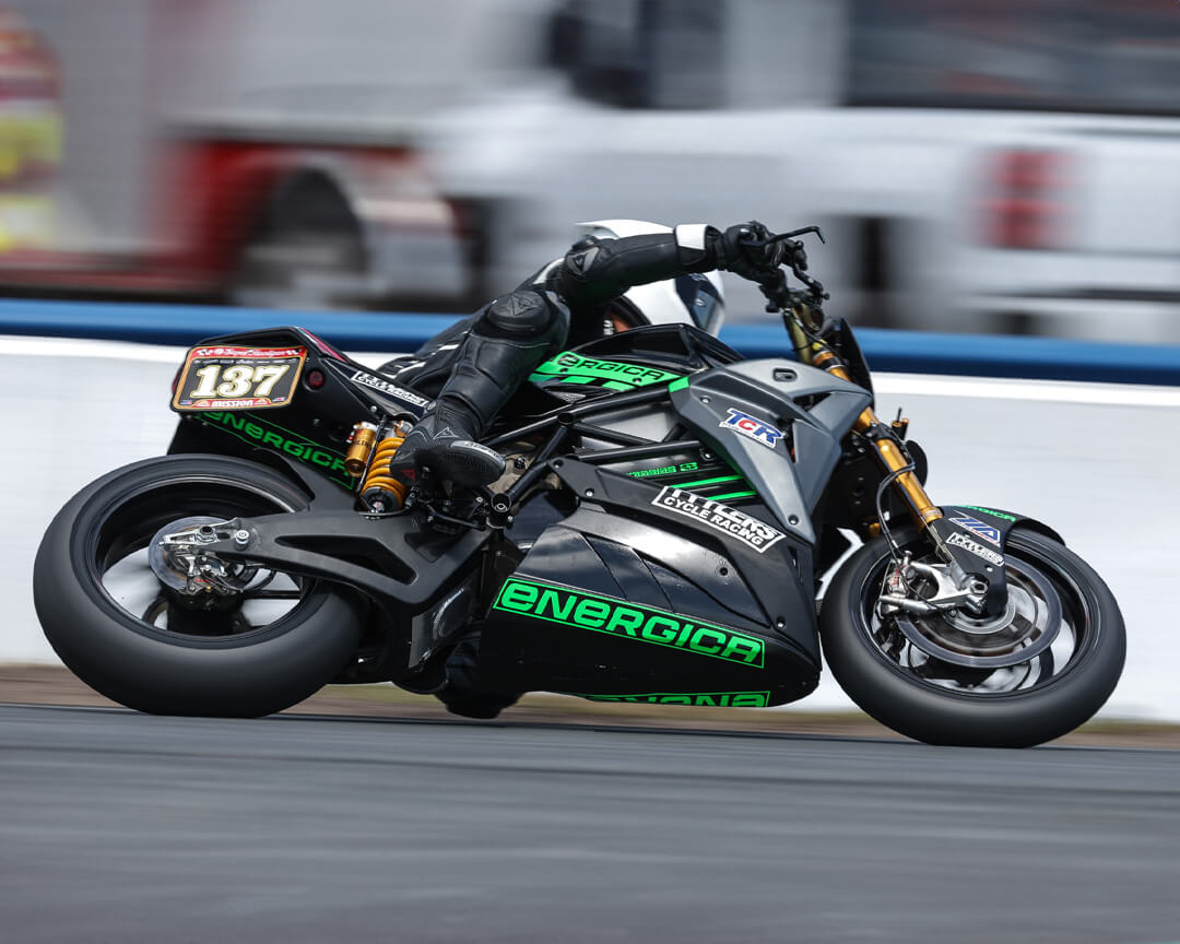 A rider riding an energica racing bike faces a curve of the track