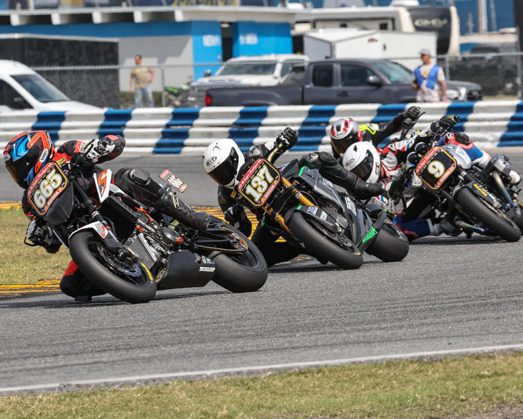 A series of racing bikes, including an energica bike, face a turn during a race