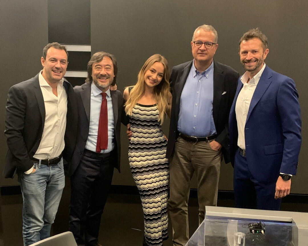 photo of Carolina Tedeschi in the company of gentlemen in a suit and tie looking at the lens smiling