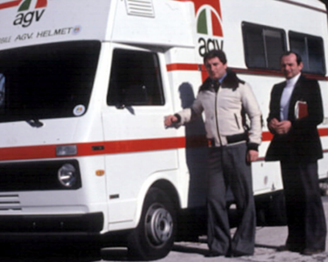 Doctor Costa standing next to the camper of the Mobile Clinic winter dress