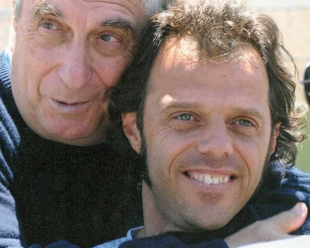 very close up of doctor Costa hugging from behind Loris Capirossi