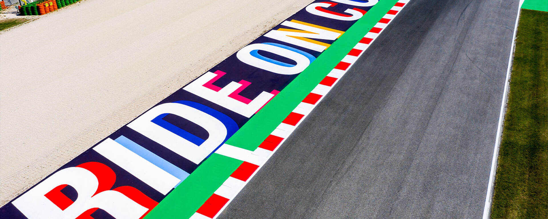 detail on straight of the circuit of Misano with colored asphalt curb and written ride on colors and sand