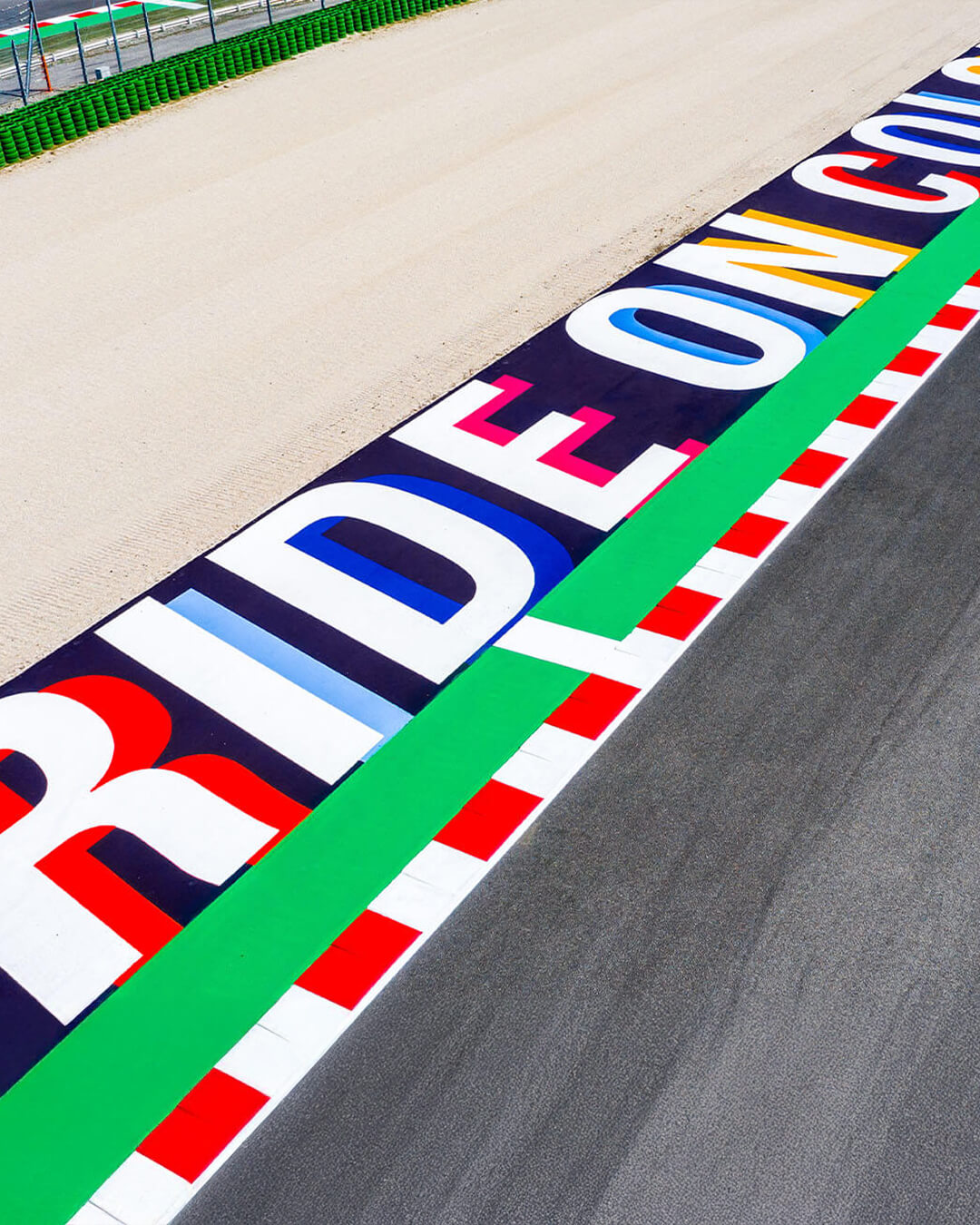 detail on straight of the circuit of Misano with colored asphalt curb and written ride on colors and sand