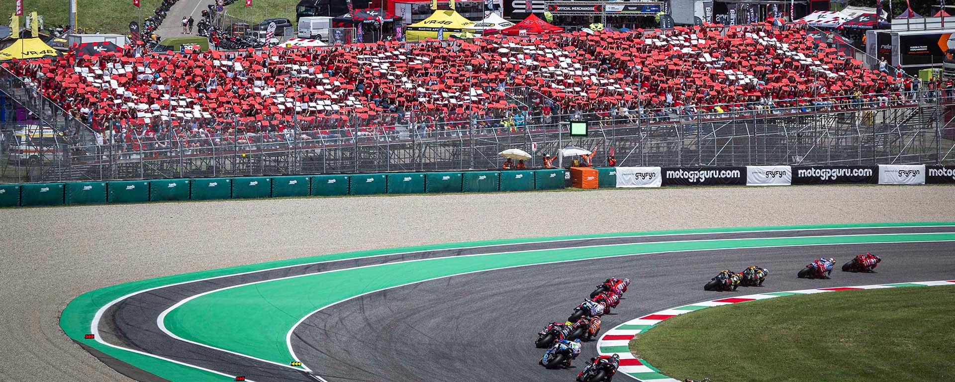 tribuna Ducati al circuito del Mugello, con piloti in curva che scorrono via